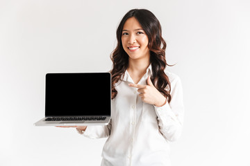 Smiling young asian businesswoman pointing