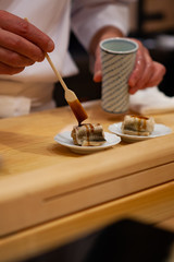 Professional and experienced sushi chef carefully add final touch with confident and dedication to his perfect sushi. Precision and Finesse at its best practice to achieve top performance in business.