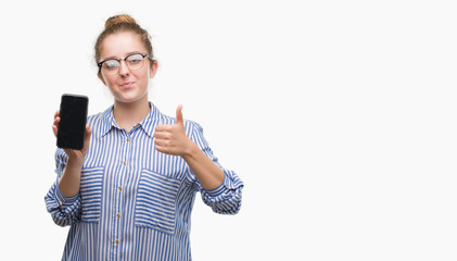 Young blonde woman using smartphone happy with big smile doing ok sign, thumb up with fingers, excellent sign