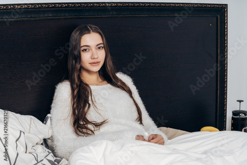 Charming Sleepy Girl With Long Hair Sitting In Bed Late At Night