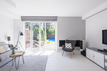 Patterned pillow on armchair in spacious living room interior wi