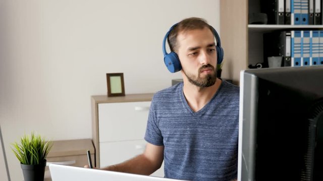 Professional graphic designer listening to music and working in his office