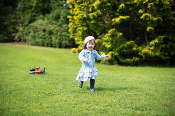 baby girl play bike in Summer forest park