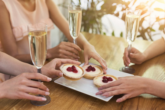 Small cake and champagne glasses in gerls hands