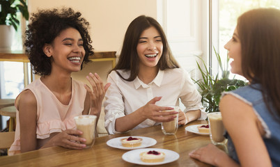 Happy girls meeting at cafe for cup of coffee