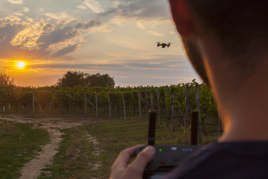 mann filmt sonnenuntergang in den weinbergen mit einer drohne