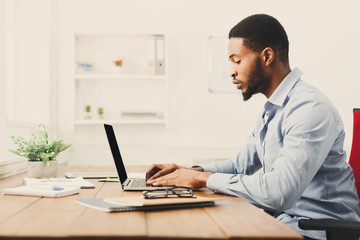 Fototapeta premium Young black businessman working with laptop