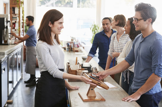 Customers Queuing To Order And Pay At A Coffee Shop