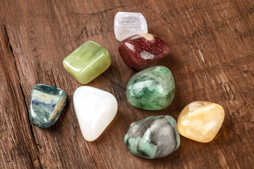 Semi precious gemstones on a dark wooden background with copy space