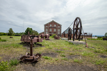 Abandoned Industrial Site. Mining machinery abandoned in a field at the Quincy Mine in the Keweenaw National Historical Park in Calumet, Michigan