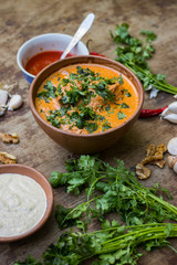 Harcho or Kharcho traditional Georgian soup food in Mingrelia with beef or chicken, rice, cherry plum purée and chopped walnut and decorated with fresh chopped coriander leaves. Georgia Samegrelo food