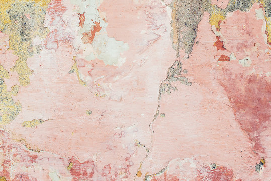 Old colored cracked wall. Grunge wall texture for design. Colored cracked background. Old paint texture is chipping and cracked fall destruction. Background of old pink painted wall.