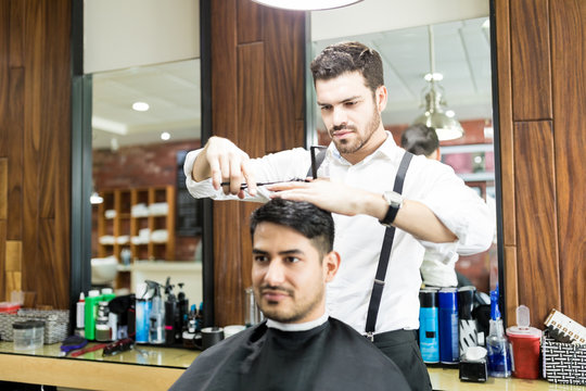 Hairstylist Focusing On Cutting Hair Of Customer In Salon