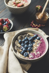 Delicious smoothie bowl with blueberries, rolled oats and chia seeds on the wooden background