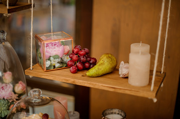 Terrarium with a peony flower, grapes, pear and candle