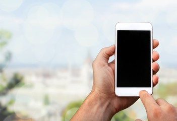 Hand holding smartphone on blurred background