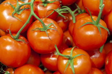 Heap of fresh ripe red tomatoes without branches close up.