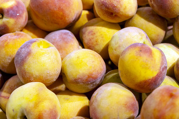 Juicy fruits of peach nectarines are spread out in even rows in the shop window
