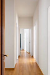 White corridor with parquet and open doors