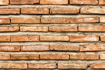 A dark red texture from an old brick wall. A destructive destruction of a brick wall. Brick background for text.