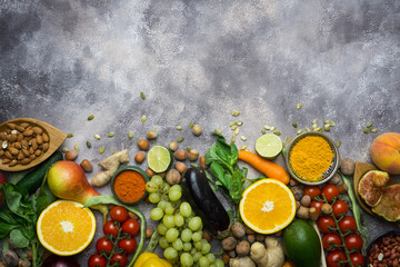 Healthy food background, frame of organic food. Ingredients for healthy cooking: vegetables, fruits, nuts, spices. Balanced diet food on a dark black background. Top view. Copy space on top