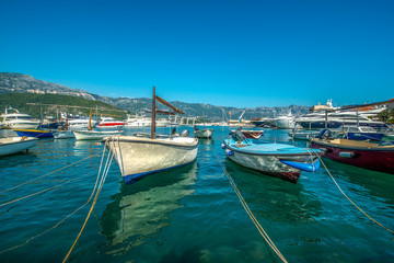 Fototapeta na wymiar małe drewniane łodzie przycumowane w zatoce na wyspie, Budva