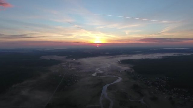 Aerial View. Panoramic summer morning landscape. The picturesque landscape with river, dam on the river, trees and field with Incredible sun. Morning Fog.