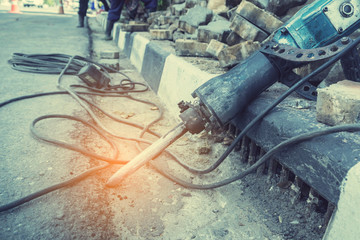 labors are constructing pedestrian walkways; workers building and installing stone tiles to build footpath