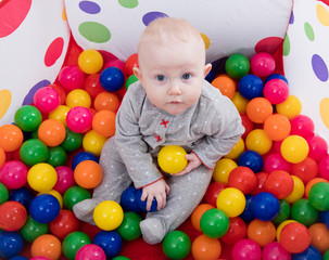 Fototapeta na wymiar Baby playing with balls in the playground 