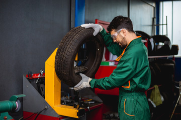 Fototapeta premium Worker reparing tire in workshop