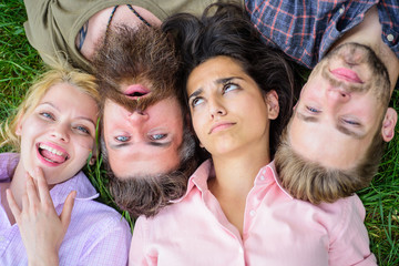 Friendship through whole life. Company friends lay grass top view. Blonde or brutal hipster friends same wave. Diversity concept. Different but still best friends. Youth men and women head to head