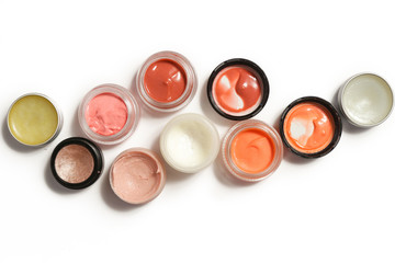 Creamy make up products - top view of decorative cosmetic containers isolated on white backgroiunds