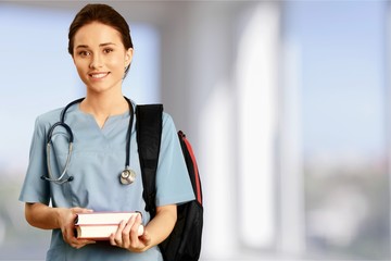 Attractive young female doctor with blurred hospital