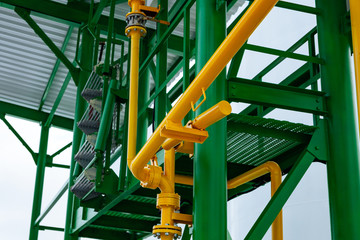 Bright green, yellow metal structure of pipes and stairs
