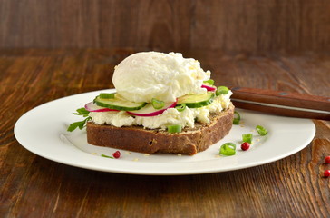 Sandwich with cream cheese, radish, cucumber and poached egg