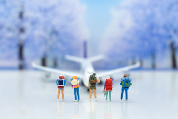 Miniature people: backpacker waiting for plane go to destination plan. Image use for business travel background concept.