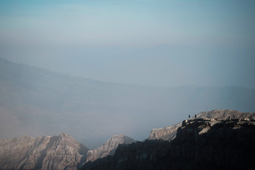 Fototapeta premium men standing on cliff at Kawah Ijen Volcano mountain, Indonesia
