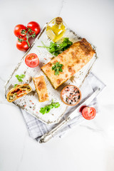 Vegetable savory strudel, homemade autumn baking, with tomatoes, bell pepper, mushrooms, wooden background copy space