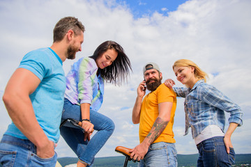 Fototapeta premium Double date concept. Group friends hang out with bicycle. Company stylish young people spend leisure outdoors sky background. Cycling modernity and national culture. Couple meet friends with bicycle