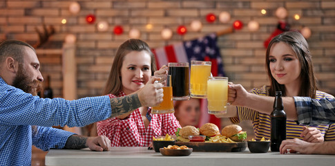 Friends clinking glasses with beer in sport bar