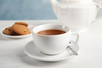Cup of delicious tea with saucer on table