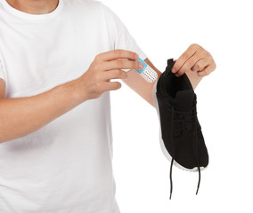 Man putting capsule shoe freshener in footwear on white background