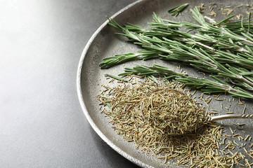 Plate with dried rosemary and twigs on table, closeup