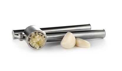 Garlic press and cloves on white background. Kitchen utensil