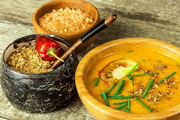 Hokkaido pumpkin soup. Vegetarian food. Wooden bowl with spicy soup on an old wooden table.