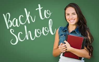 Back To School Written On Chalk Board Behind Mixed Race Young Girl Student Holding Books