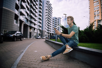 Face recognition. Biometric verification. The concept of a new face recognition technology on a polygonal mesh. Young modern guy with a smartphone in his hands. Young man with phone in hands.