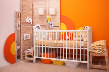 Obraz na płótnie Canvas Baby room interior with crib near color wall