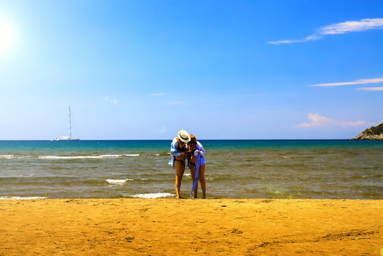2 girls are reviewing newly taken photos on the picturesque coast of the Aegean Sea. Turkey