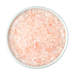 Himalayan pink salt in white bowl on white isolated background. Top view.